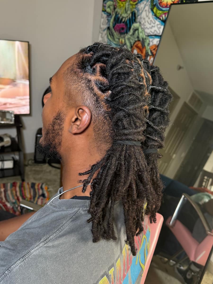 Loc retwist styled into a layered ponytail with a skin fade, side view