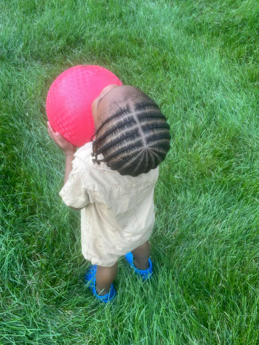 Child's cornrows braided straight back, outdoors