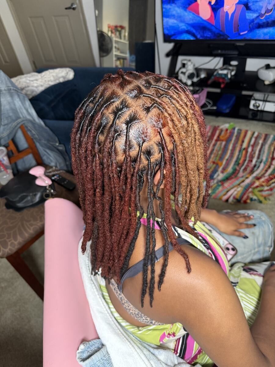 Locs colored copper and honey blonde with starburst parts, back view